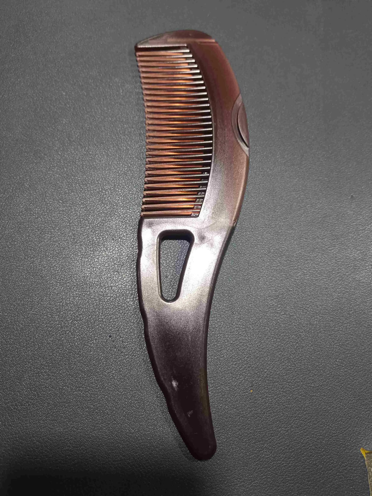 Dandruff removal comb showing textured teeth